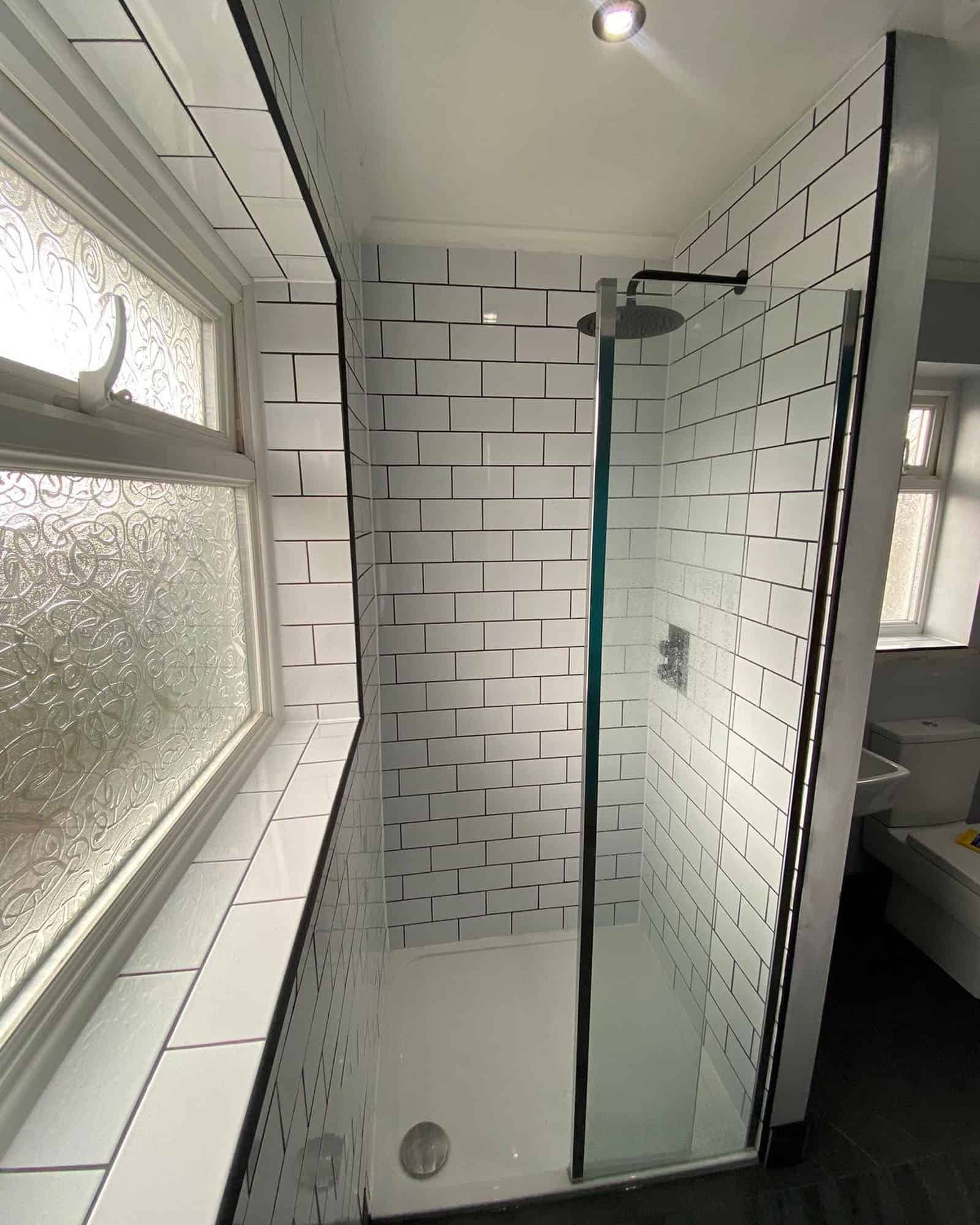 Modern white subway tile shower with glass door